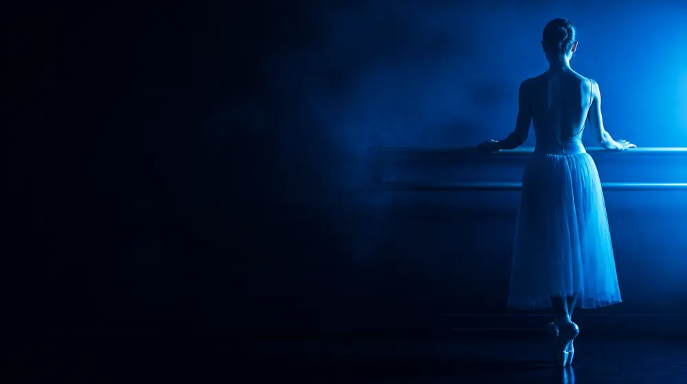 Ballerina OnlyFans creators — ballerina at a barre in a dim blue-lit studio