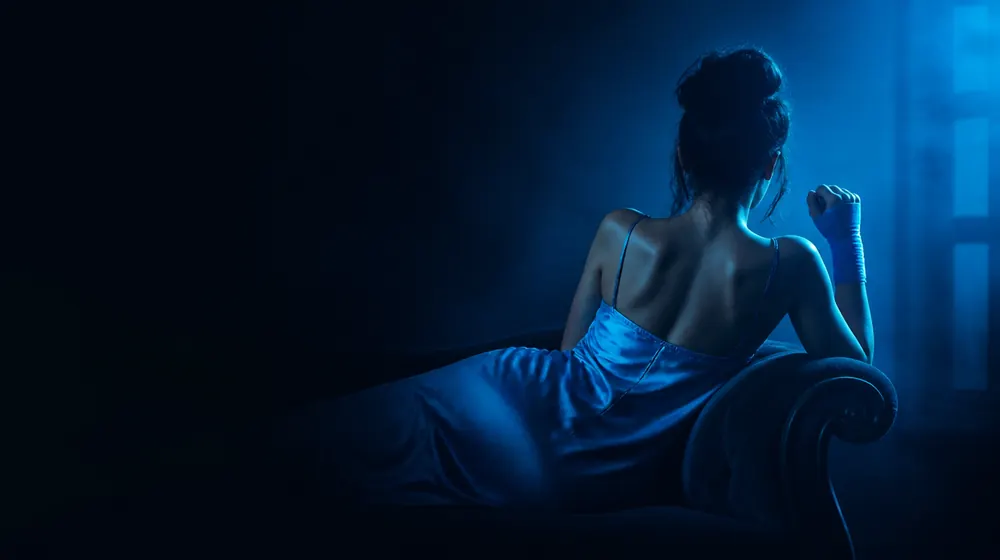 Fisting OnlyFans creators — woman in a silk slip dress reclining on a chaise longue, a boxing wrap wound around her fist